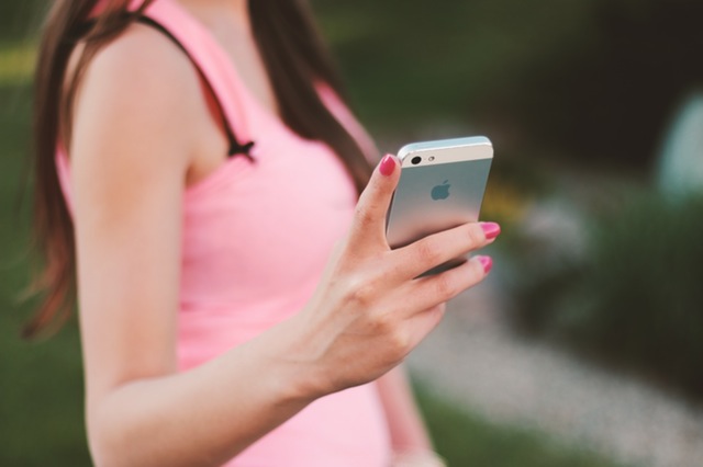 すっきりした気持ちで電話を切る女性 Photo By PEXELS